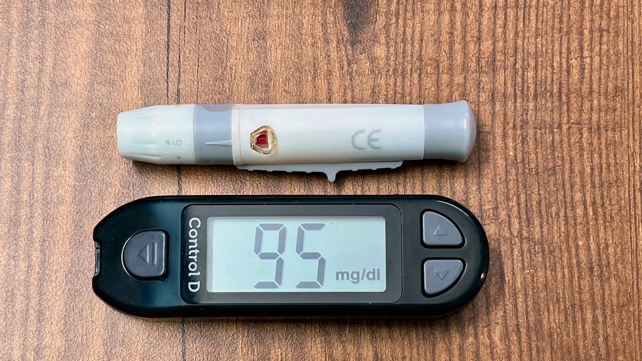 Blood sugar glucometer on a surface, representing metabolic health monitoring with berberine
