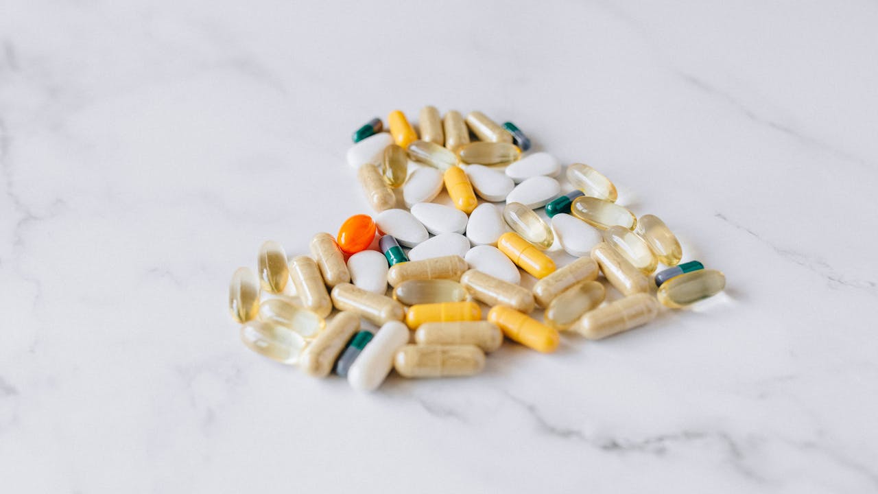 Variety of supplement capsules and pills on a marble surface representing berberine supplements