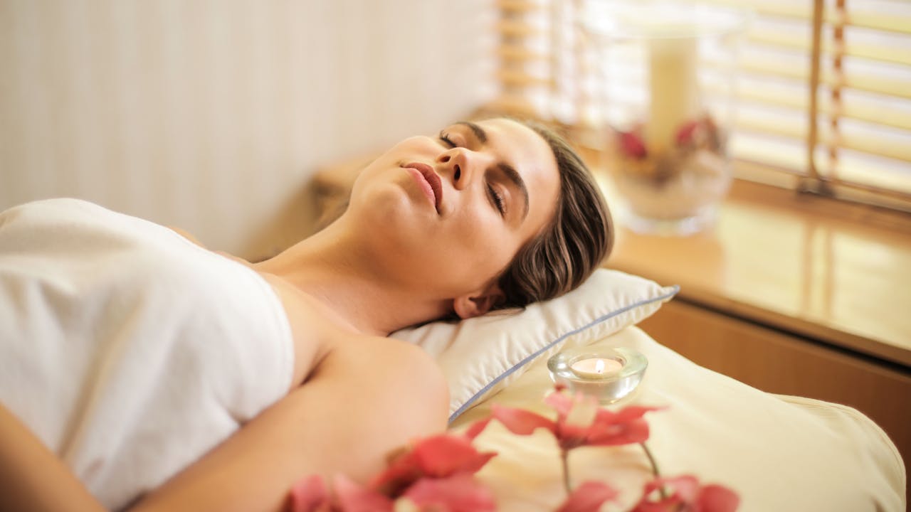 Woman sleeping peacefully in a warm bedroom, representing restorative deep sleep