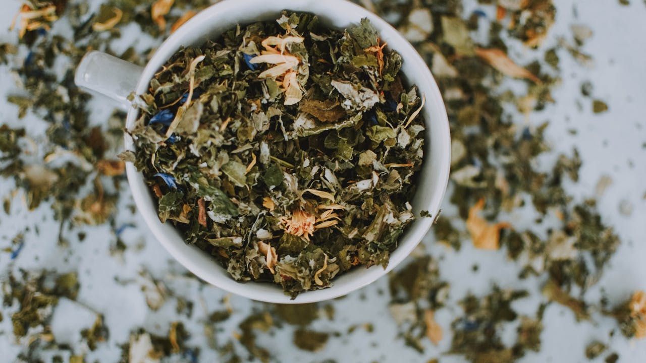 Fresh green tea leaves and a cup of green tea, natural light photography