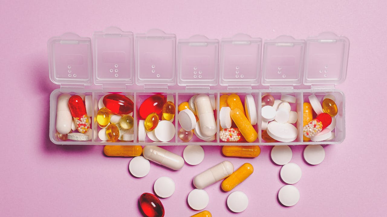 Supplement capsules in various amber glass bottles arranged on a health and wellness flat lay