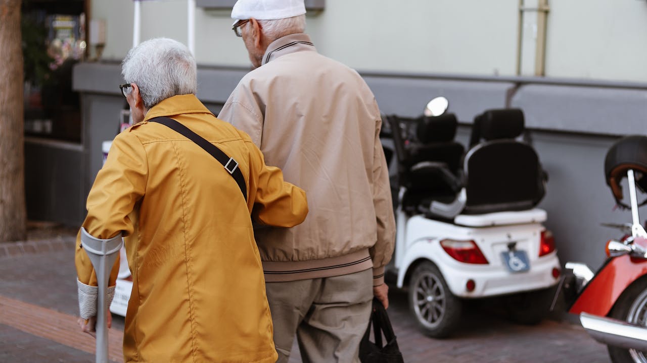 Senior couple walking together on a quiet road surrounded by trees, enjoying an active healthy lifestyle