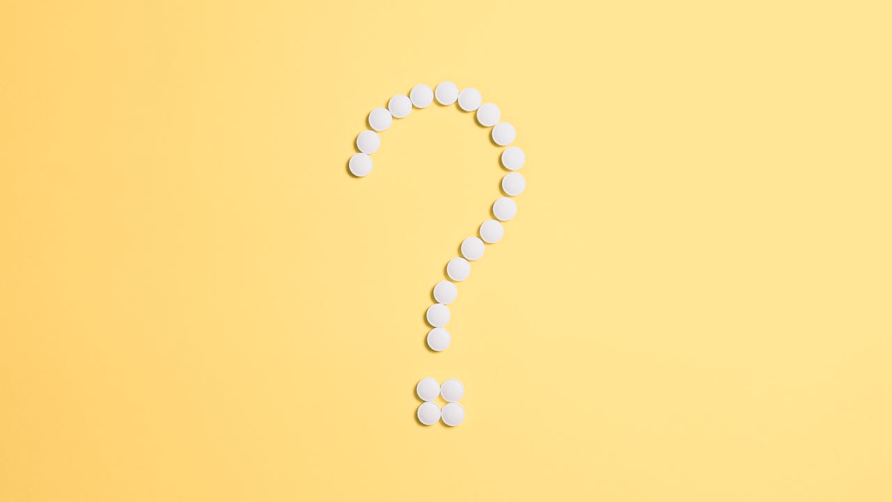 Pharmaceutical capsules arranged on a clean marble surface representing longevity supplement protocols
