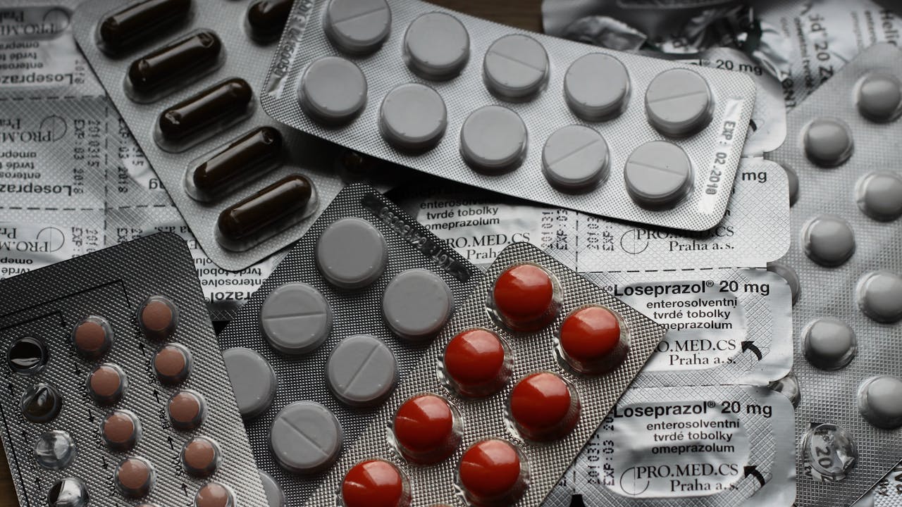 Medicine capsules in white tones on a neutral surface