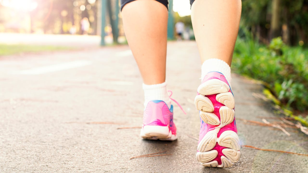 Healthy active older adult running outdoors in morning light
