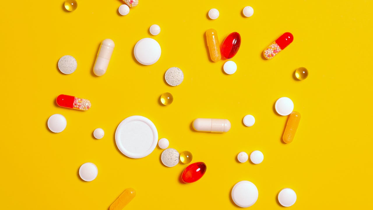 Pharmaceutical methylene blue vial and supplement capsules on a white marble surface